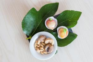 a bowl of nuts next to a green leaf at Palmares Beach House Hotel - Adults Only in Lagos