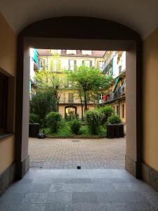 トリノにあるCasamartinaの木々や建物のある中庭への開放的な出入り口