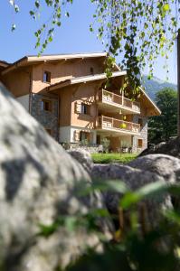 een huis op een heuvel met rotsen ervoor bij CGH Résidences & Spas La Reine des Prés in Samoëns