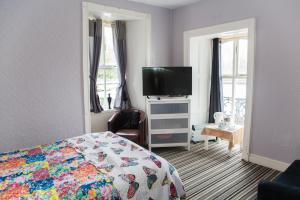 Schlafzimmer mit einem Bett und einem Flachbild-TV in der Unterkunft Anglesey Arms in Caernarfon