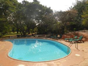 a large swimming pool with chairs and a table at Kilaguni Serena Safari Lodge in Tsavo