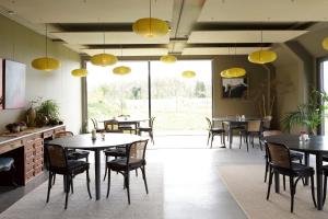 エークトにあるLandhuis Hotel Rikusのテーブルと椅子、黄色の照明が備わるレストラン