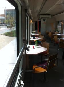 a dining car of a train with tables and chairs at Train Lodge Amsterdam in Amsterdam