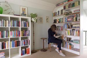 a woman sitting in a chair in a library at Landhuis Hotel Rikus in Eext