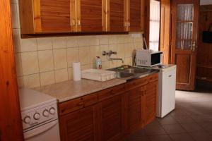 a kitchen with a sink and a stove and a microwave at A cigándi bíró háza in Cigánd