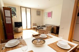 eine Küche und ein Wohnzimmer mit einem Tisch und Weingläsern in der Unterkunft Penthouse Vallespir in Barcelona