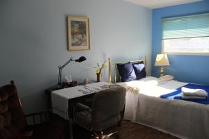 um quarto com uma cama e uma secretária com uma cadeira em Winnipeg Homestay em Winnipeg