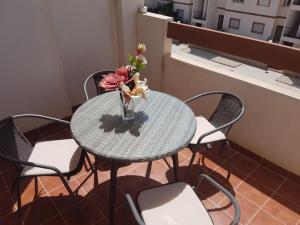 オリフエラ・コスタにあるApartments La Cinuelica R17 PP014のテーブルと椅子、花瓶