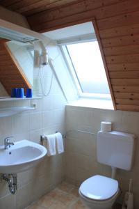 a bathroom with a sink and a toilet and a window at Gasthof Neusitz in Neusitz