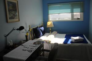 a bedroom with a bed and a desk and a window at Winnipeg Homestay in Winnipeg