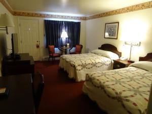 pokój hotelowy z 2 łóżkami i stołem w obiekcie Amish Country Motel w mieście Bird in Hand