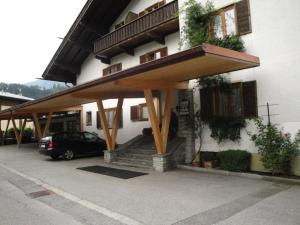 awning on the side of a building with a car parked under it at Gästehaus Brindlinger in Zell am Ziller