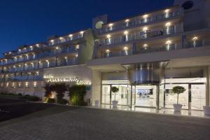 un gran edificio con un cartel en él por la noche en Mar Hotels Playa de Muro Suites, en Playa de Muro