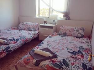 オリフエラ・コスタにあるApartments La Cinuelica R17 PP014の小さなベッドルーム(ベッド2台、ナイトスタンド付)