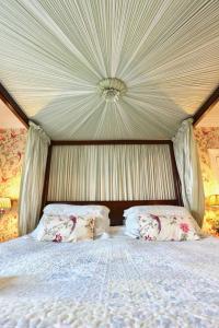 a canopy bed with two pillows in a bedroom at The Old Vicarage in Leyburn