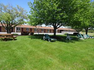 a park with chairs and a picnic table in front of a building at Amish Country Motel in Bird in Hand