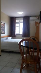 a bedroom with a bed and a table and a chair at Hotel Praia 2000 in Fortaleza