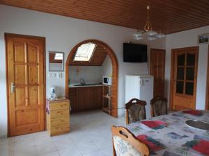 a kitchen with a table and a white refrigerator at Gold Apartment in Harkány
