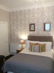 Un dormitorio con una cama grande y una pared. en The Westbourne Guest House, en Llandudno