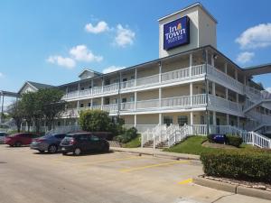un hotel con coches estacionados en un estacionamiento en InTown Suites Extended Stay Houston TX - Greenspoint, en Houston