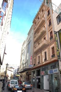 a busy city street with cars driving past a building at Hotel Real Castellon in Castellón de la Plana