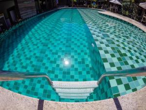 uma piscina com piso em azulejo verde e branco em Terra Boa Hotel Boutique em Itacaré