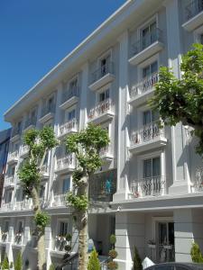 Un gran edificio blanco con árboles delante. en Innova Sultanahmet Istanbul, en Estambul