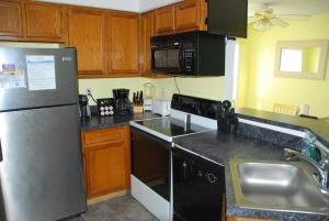 a kitchen with a stainless steel refrigerator and a sink at Station One by Kees Vacations in Kill Devil Hills