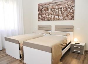 アレッツォにあるCasa Vacanze Centro Fiereの壁に絵画が飾られたベッドルーム1室(ベッド2台付)