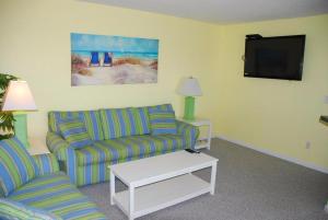 a living room with two couches and a flat screen tv at Station One by Kees Vacations in Kill Devil Hills