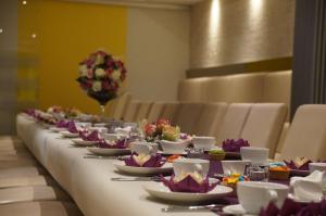 uma mesa longa com pratos, copos e flores em Hotel h4 easy em Eschweiler