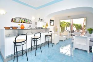 a restaurant with blue tile floors and a bar with stools at Charme Hotel La Villa Tina in Ischia