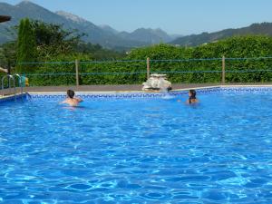 dos personas en una piscina en el agua en Camping Colombres, en Colombres