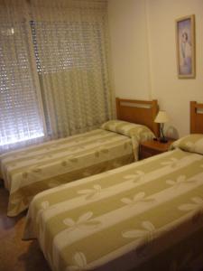 1 dormitorio con 2 camas y ventana en Eden Park - Fincas Arena, en Benidorm