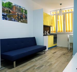 Una sala de estar con un sofá azul y una cocina. en Downtown Tirana Apartments, en Tirana