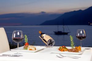 a table with a bottle of wine and two glasses at Lukka Exclusive Hotel – Adult Only +12 in Kaş