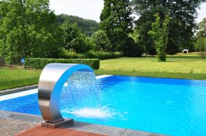 a fountain in the middle of a swimming pool at Parkhotel Bad Schandau mit SPA in Bad Schandau