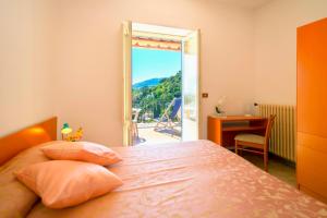 a bedroom with a bed and a door to a balcony at Villa Angela Apartment in Ischia Town