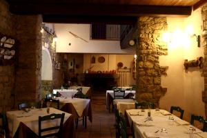 uma sala de jantar com mesas com toalha de mesa branca em Hotel Sa Lolla em Barumini