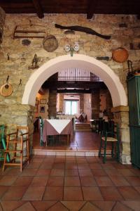 a dining room with a table in a stone wall at Hotel Sa Lolla in Barùmini