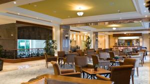 a restaurant with chairs and tables and a bar at Rixos-Prykarpattya Resort in Truskavets