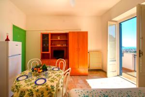 a dining room with a table and a refrigerator at Villa Angela Apartment in Ischia Town