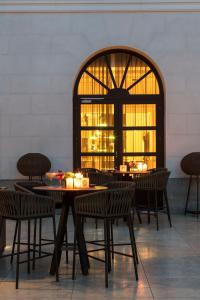 a restaurant with tables and chairs and a large window at Palacio de los Duques Gran Meliá - The Leading Hotels of the World in Madrid