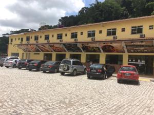 Un estacionamiento con autos estacionados frente a un edificio. en Pousada Catavento, en Piraí 4 fotos más