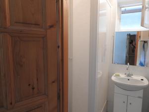 La salle de bains est pourvue d'un lavabo et d'une porte en bois. dans l'établissement Gold Apartment, à Harkány