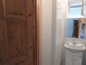 a bathroom with a sink and a wooden door at Gold Apartment in Harkány +21 photos