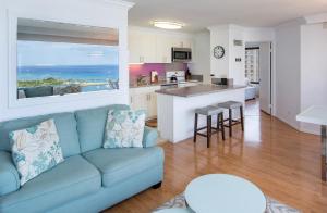 a living room with a couch and a kitchen at Signature Suites 11 in Honolulu