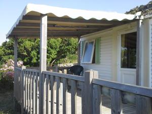 a porch of a house with a wooden fence at La Canardiere in Casta