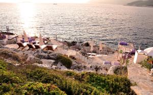a group of chairs sitting on the side of a body of water at Lukka Exclusive Hotel – Adult Only +12 in Kaş