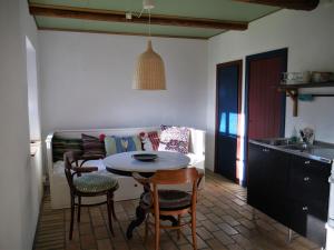 eine Küche mit einem Tisch, Stühlen und einem Sofa in der Unterkunft Onkel Enkels Pensionat in Tomelilla